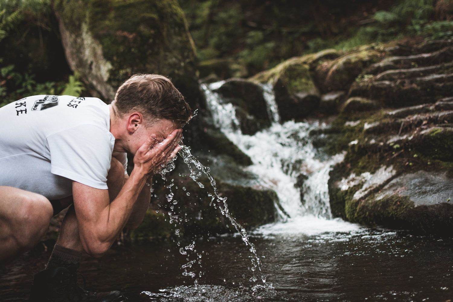 Man hydrateerd gezicht bij waterval